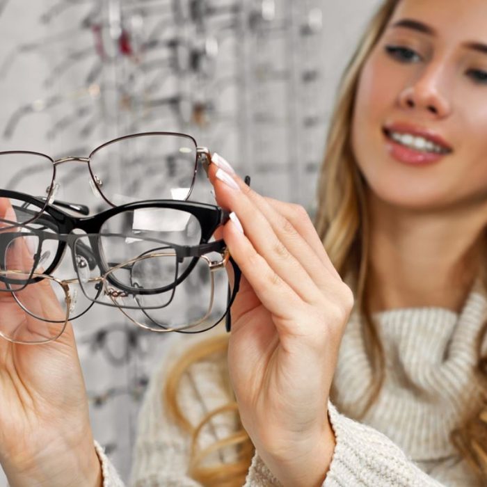 ragazza con tanti occhiali da vista in mano